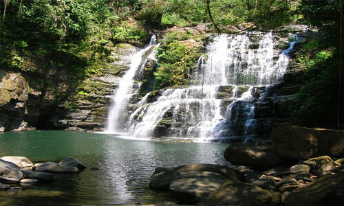 Picture of a beautiful waterfall in Costa Rica.  The picture shows green trees and a cascading waterfall along with a pond at the base.