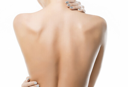 Picture of a woman with her back to the camera and happy with her perfect back liposuction procedure she had at Top Plastic Surgeons in beautiful San Jose, Costa Rica.  She has two hands positioned to highlight the areas of her back liposuction.